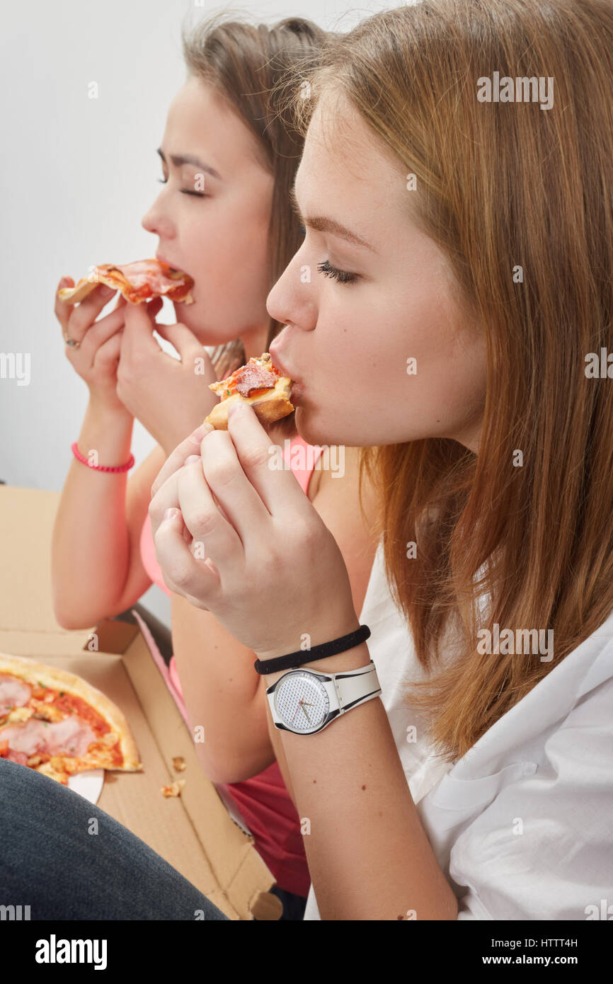 happy girls eats pizza side view portrait Stock Photo - Alamy