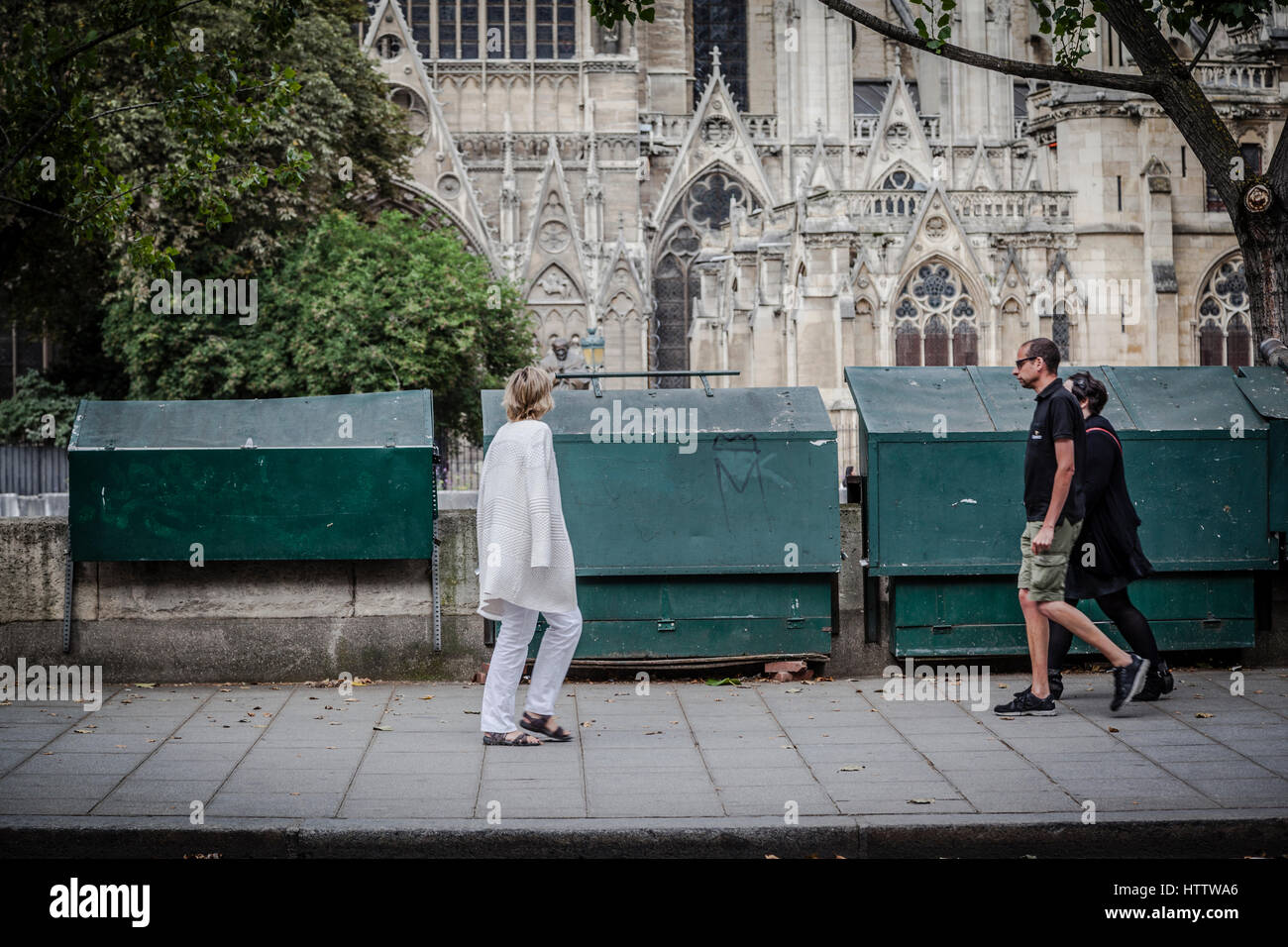 People wlaking in the Siene street shore, with Notre Dame in the back, Paris. Stock Photo