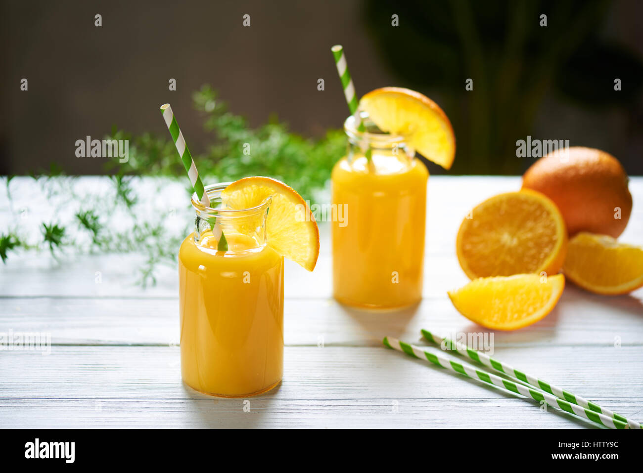https://c8.alamy.com/comp/HTTY9C/fresh-orange-juice-in-the-jar-with-straw-on-white-wood-table-vertical-HTTY9C.jpg