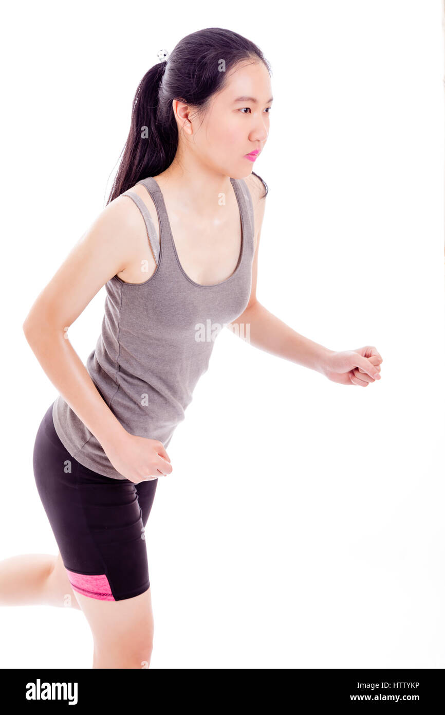 Teenage Asian girl jogging on white background Stock Photo