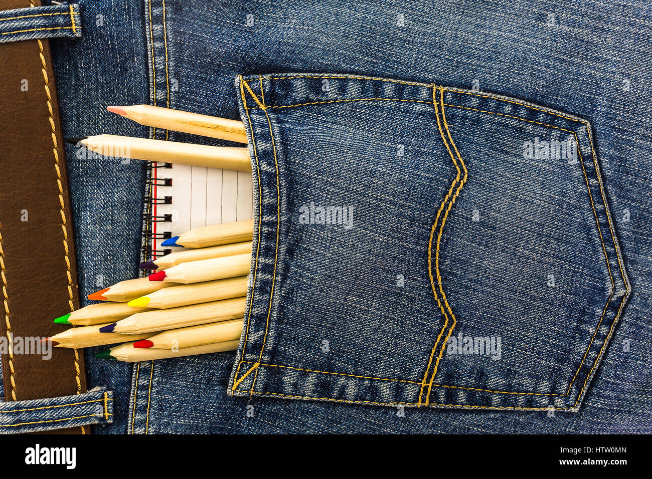 set of school pencils and small notebook in a back pocket of a blue denim jeans Stock Photo