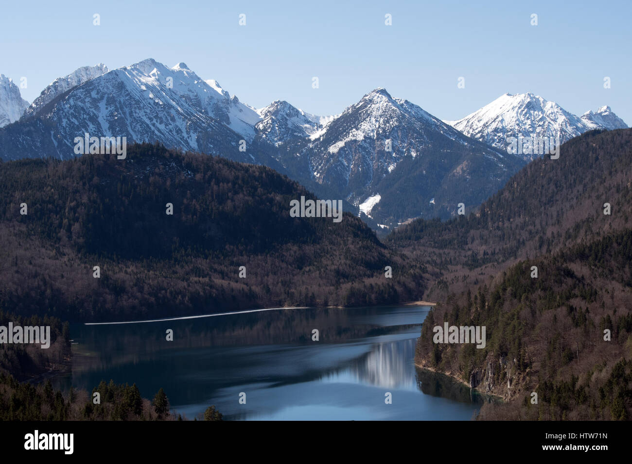 Lake with Alps in background during winter time Stock Photo