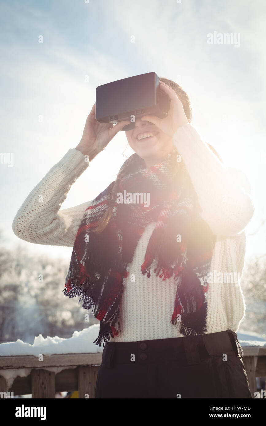 Woman in winter wear using VR headset Stock Photo
