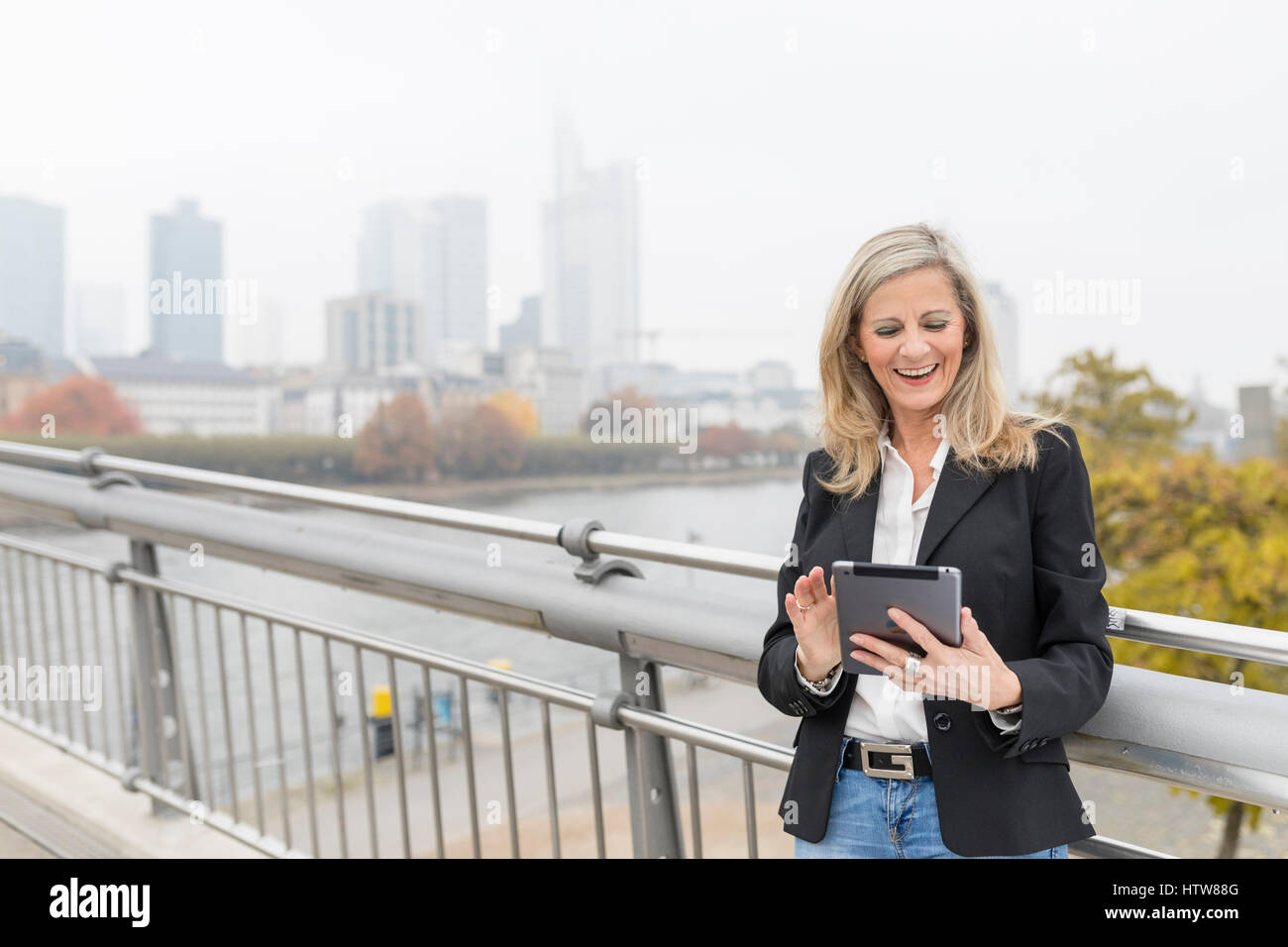 Businesswoman with tablet on a bridge Stock Photo