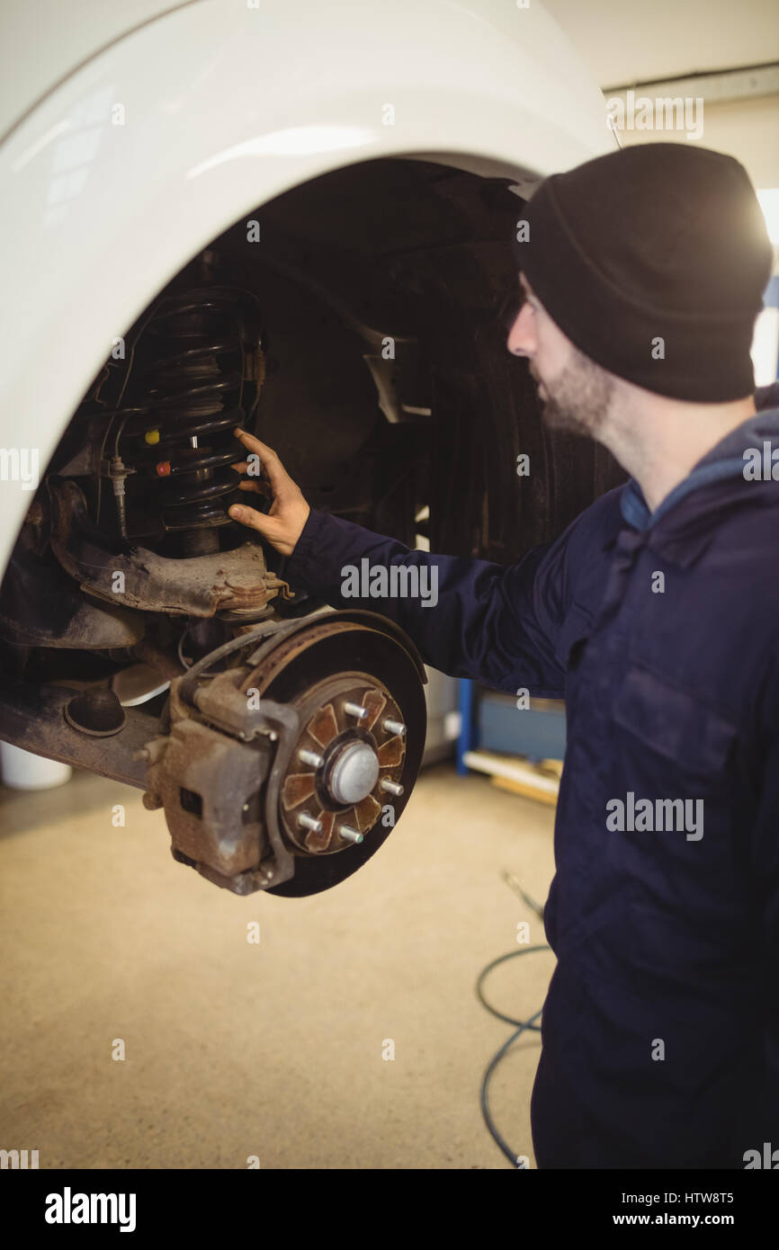 Mechanic examining a car wheel disc brake Stock Photo Alamy