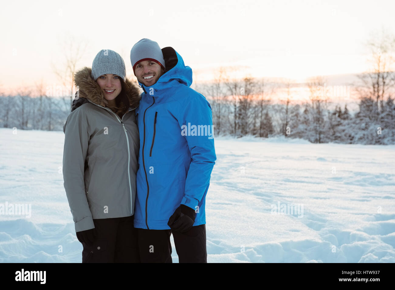 Smiling couple standing on snowy landscape Stock Photo - Alamy