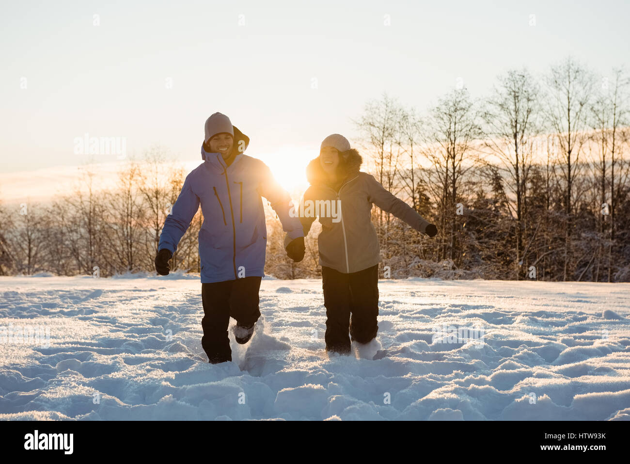 Couple walking on snow covered landscape Stock Photo