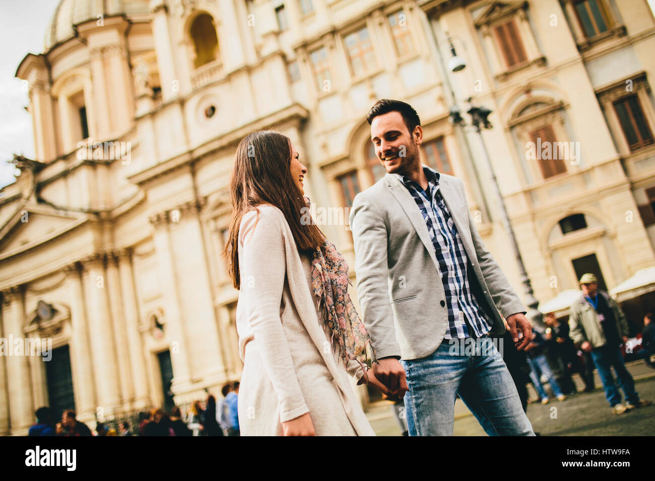 Casual young couple holding hands walking in Rome, Italy, Europe. Stock Photo
