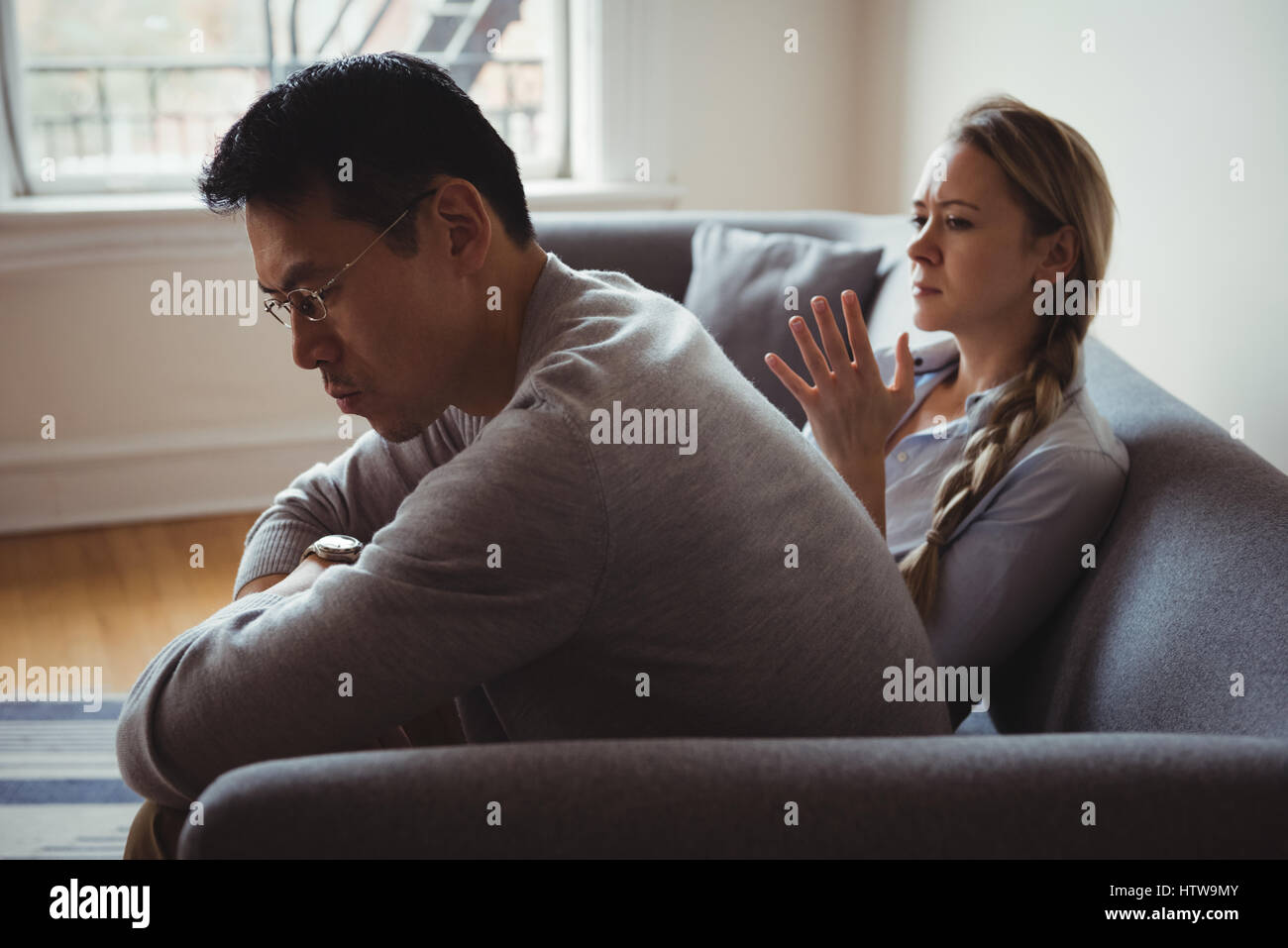 Unhappy couple arguing in living room Stock Photo