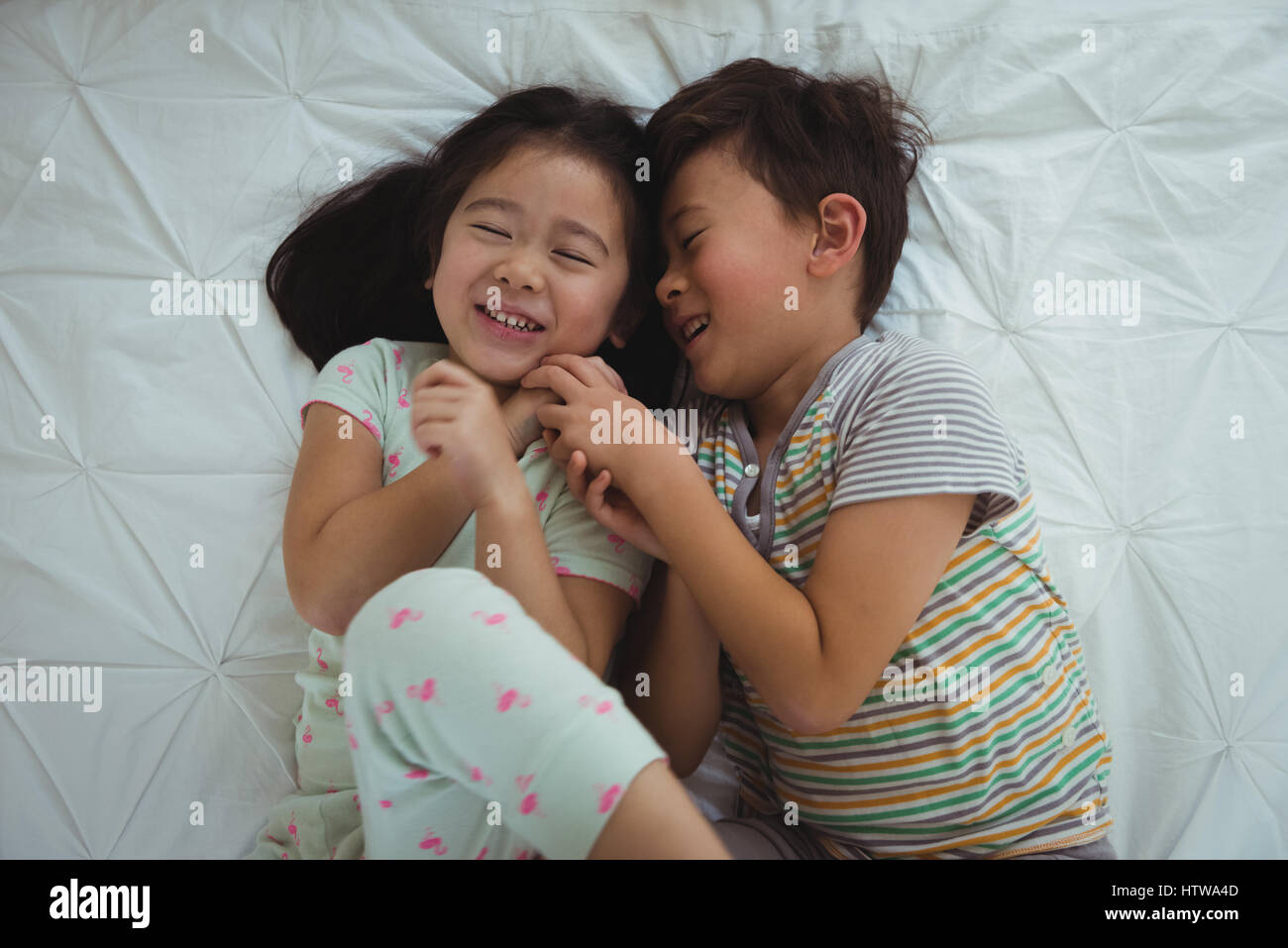 Siblings playing in bedroom Stock Photo