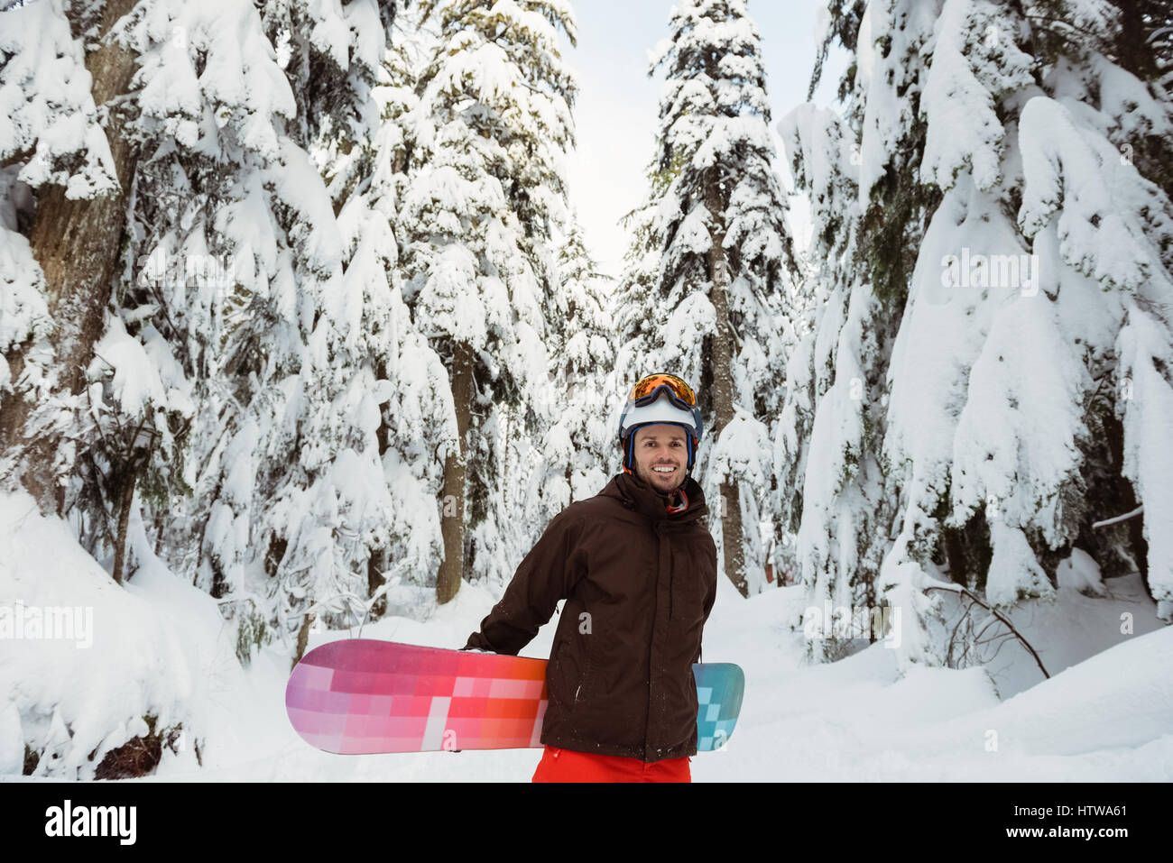 Man standing and holding a snowboard Stock Photo - Alamy