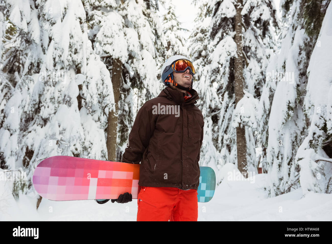 Man standing and holding a snowboard Stock Photo - Alamy
