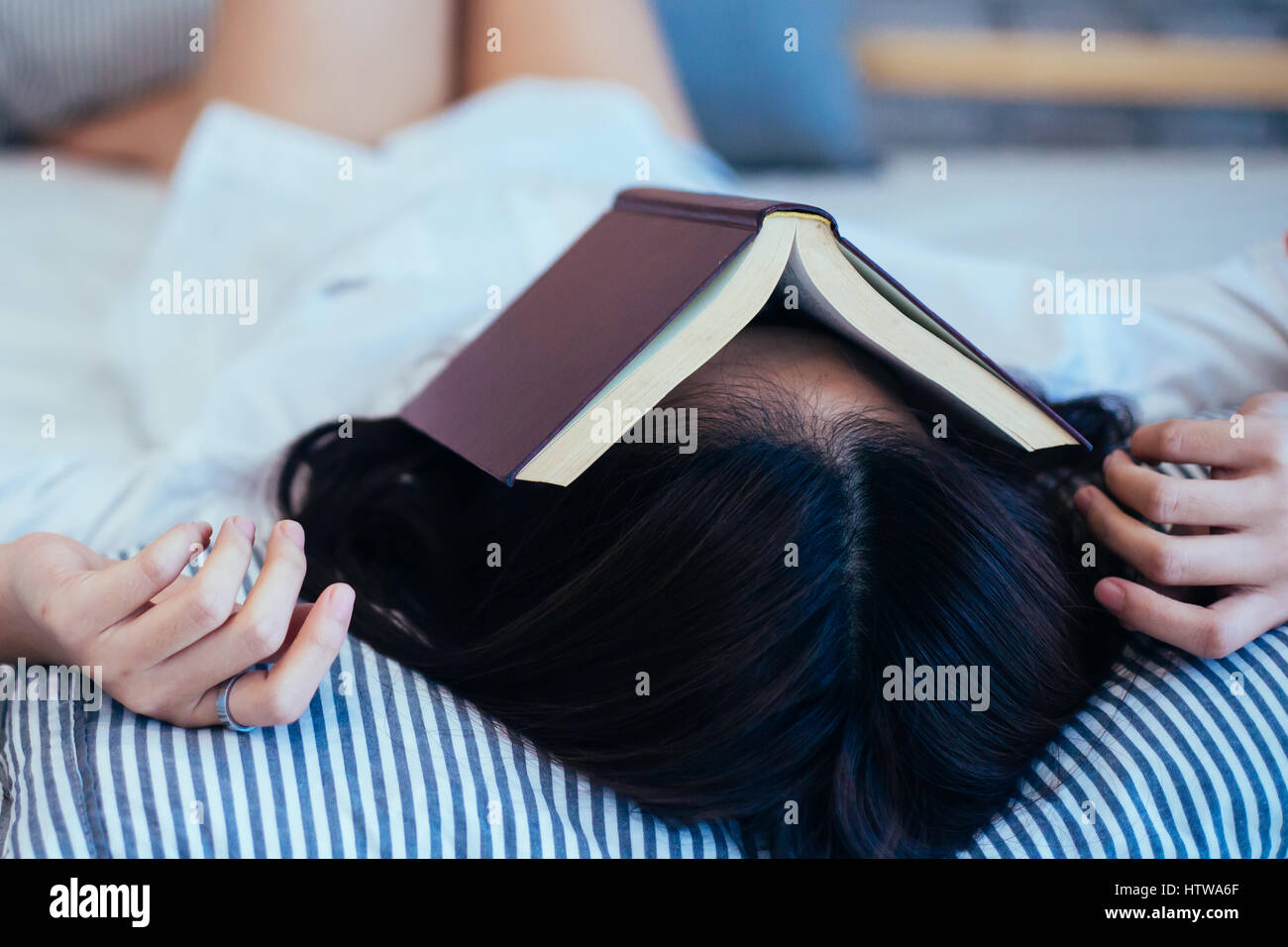 Female teen falls asleep while reading the book book on top of her