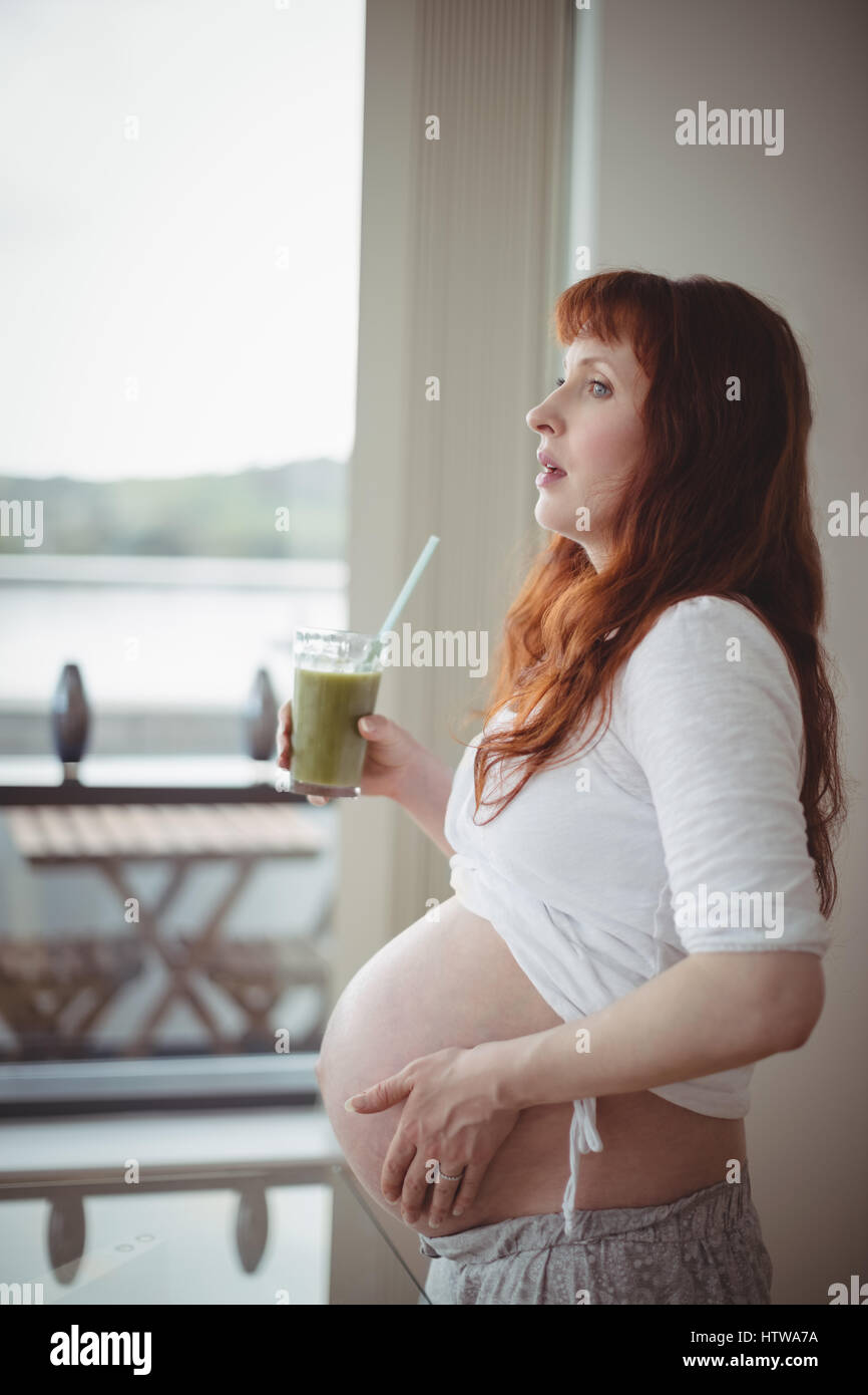 Thoughtful pregnant woman holding glass of juice Stock Photo - Alamy