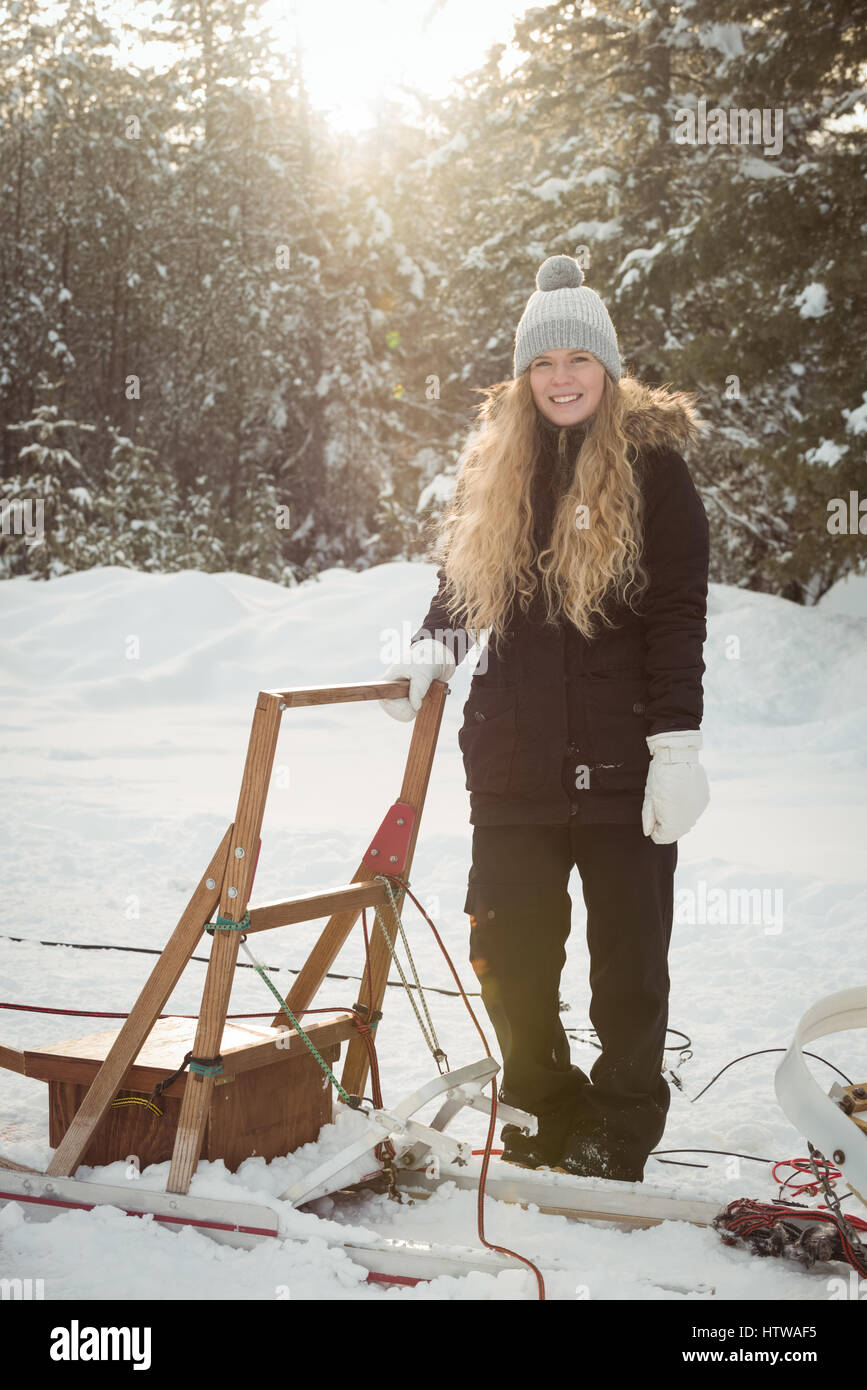 Female musher standing beside sleigh Stock Photo
