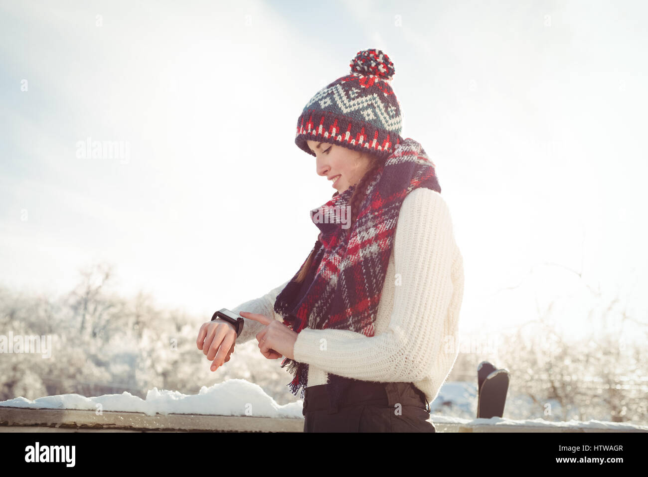 Woman in winter wear checking her smartwatch Stock Photo