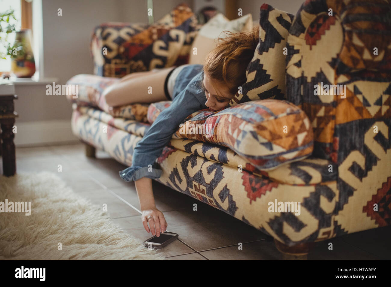 Woman lying on sofa browsing hi-res stock photography and images - Alamy