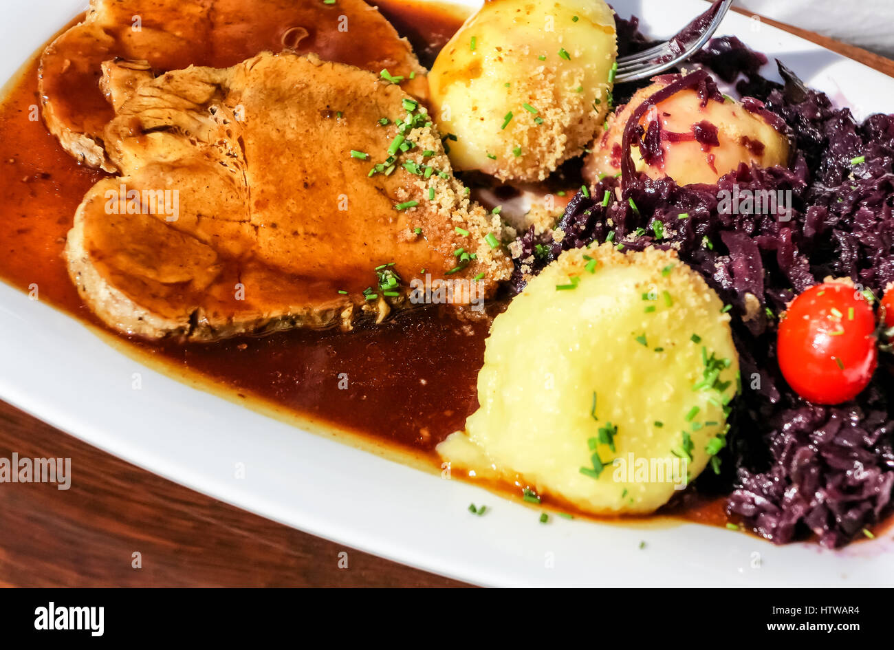 Traditional german roast pork with red cabbage, lots of sauce and