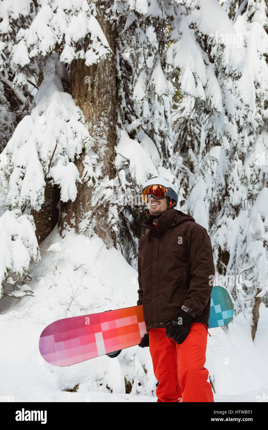 Man standing and holding a snowboard Stock Photo - Alamy