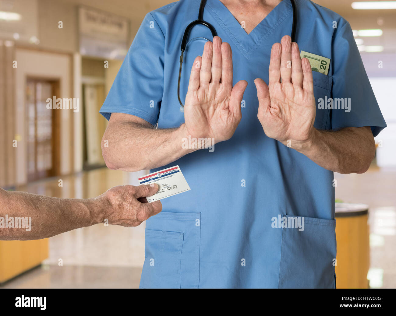 Senior doctor in scrubs refusing Medicare Card Stock Photo