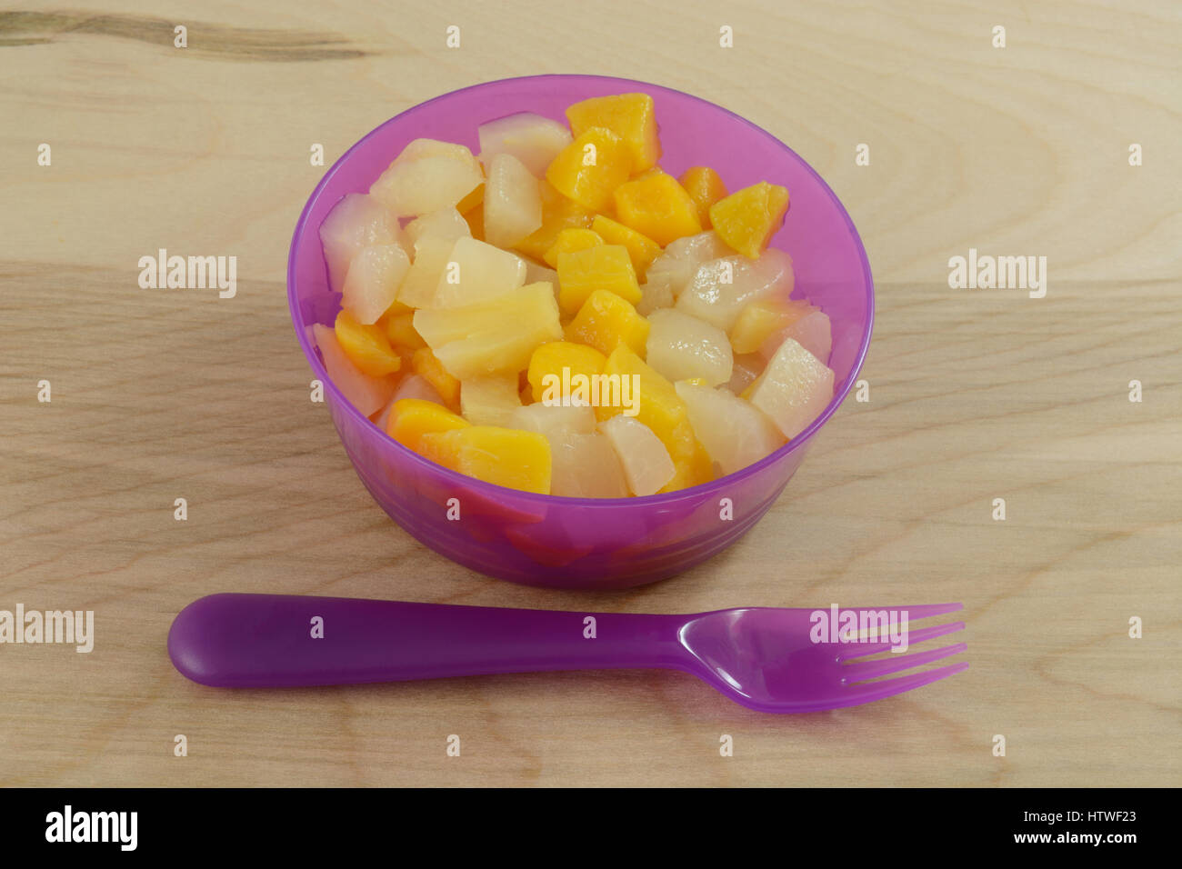 Canned mixed fruit cocktail in plastic purple portable bowl Stock Photo