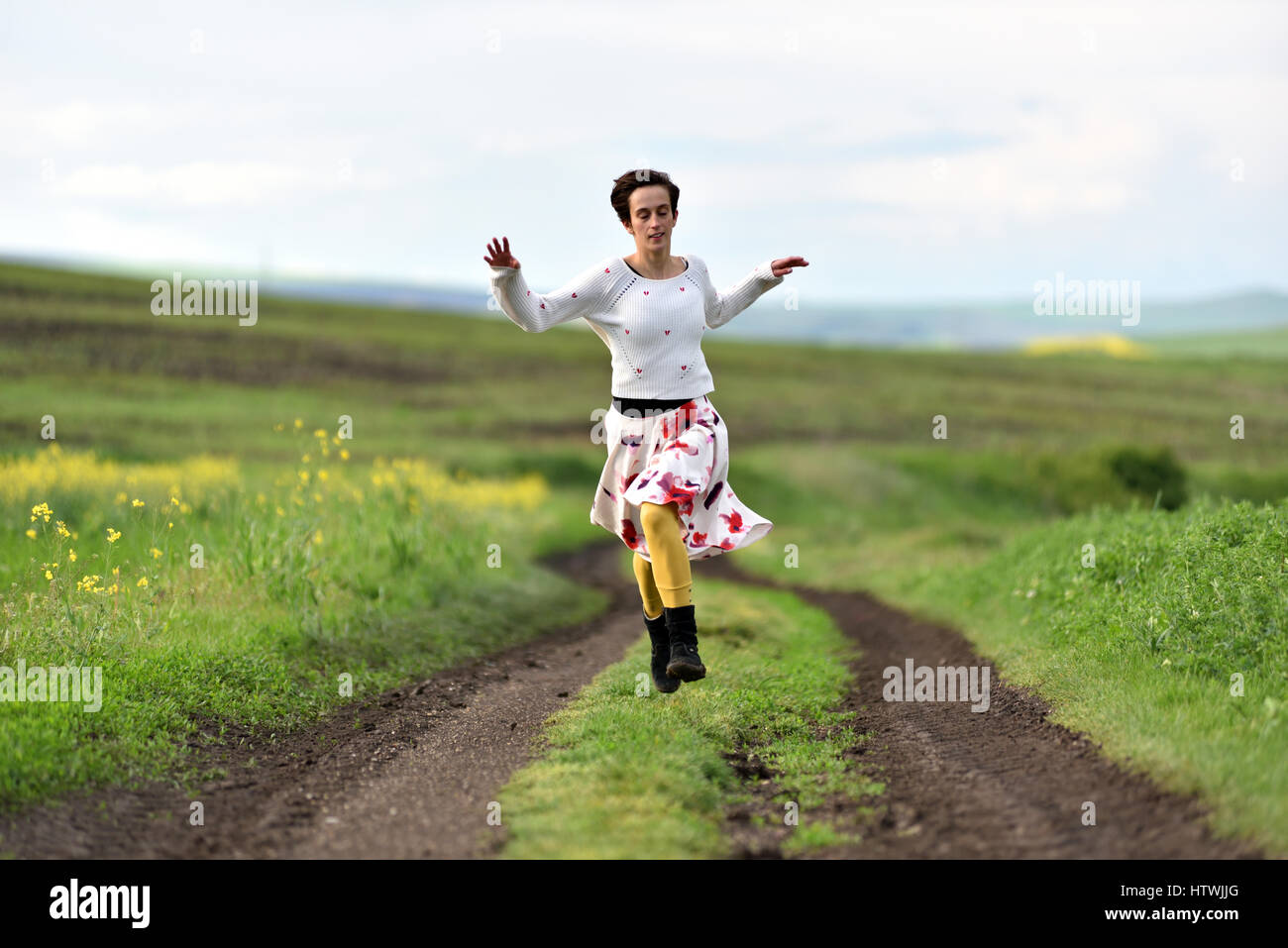 Freedom concept. Young woman running on a countryside road Stock Photo ...