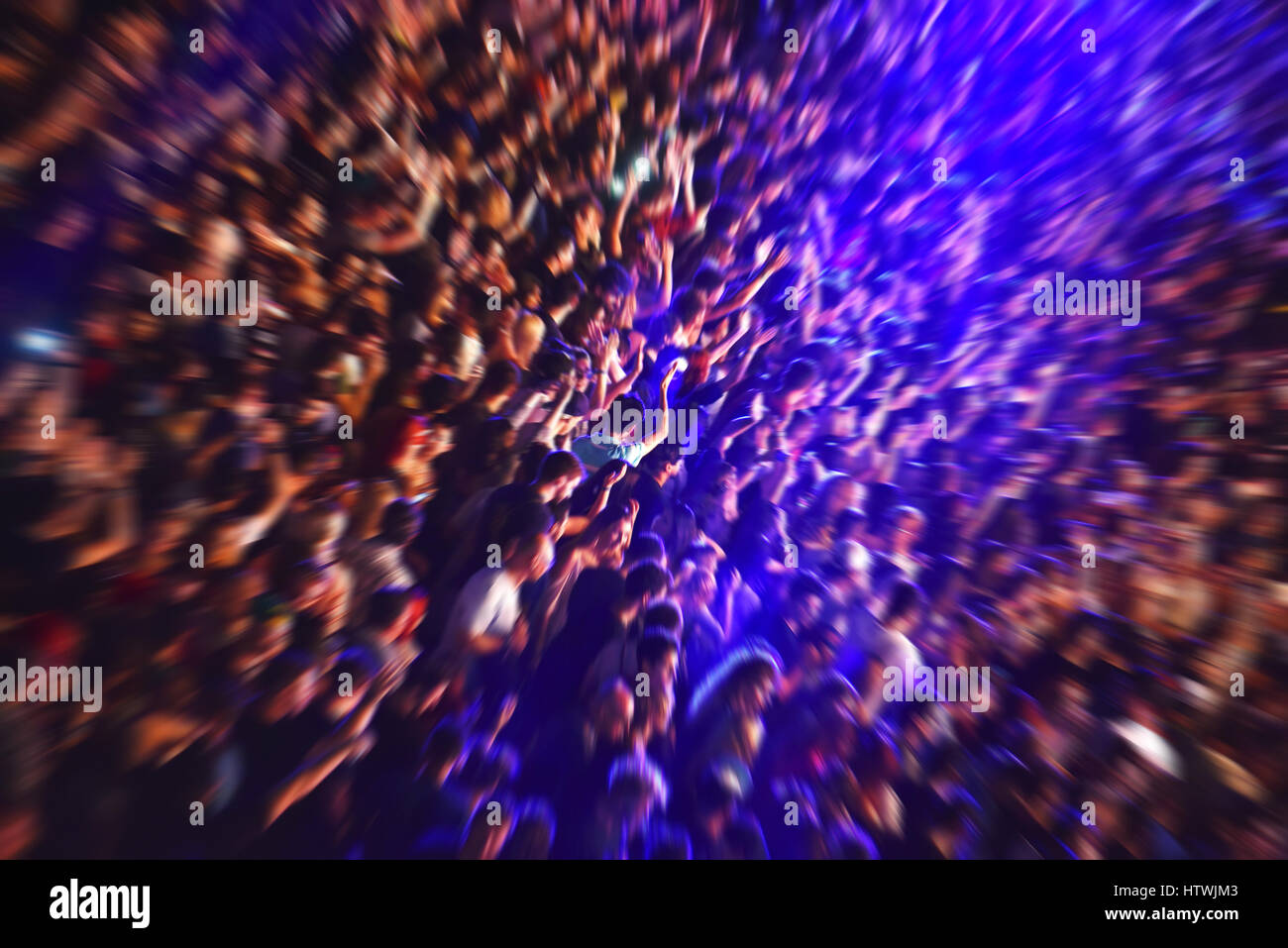 Zoom in effect on a blurred crowd partying at a music festival Stock ...