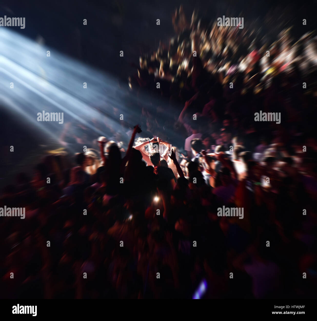 Blurred crowd partying at a music festival. Zoom in effect and stage ...