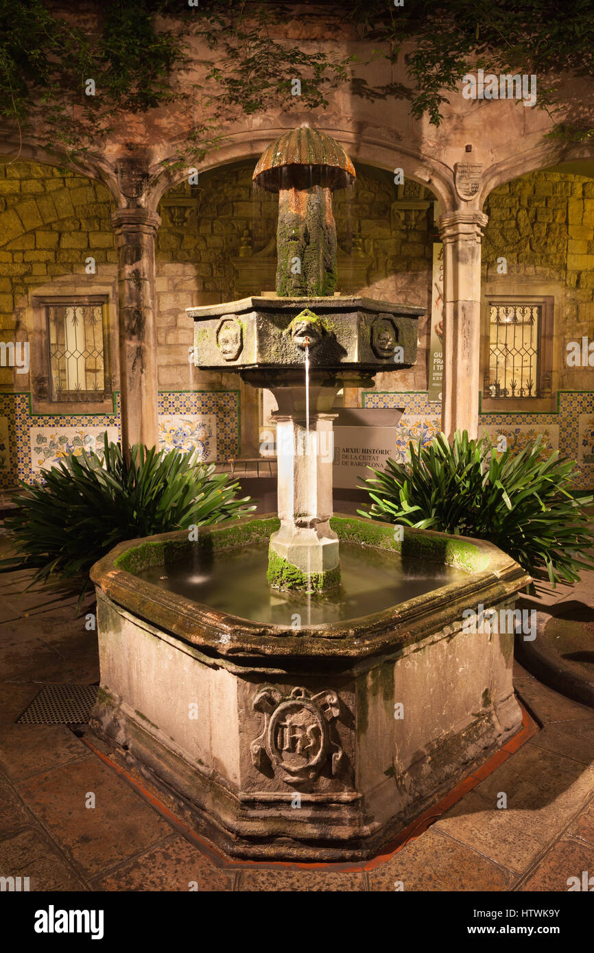 Spain, Barcelona, courtyard and fountain of Casa de l’Ardiaca House (Archdeacon's House) at night in Gothic Quarter (Barri Gotic), Historic Archive of Stock Photo