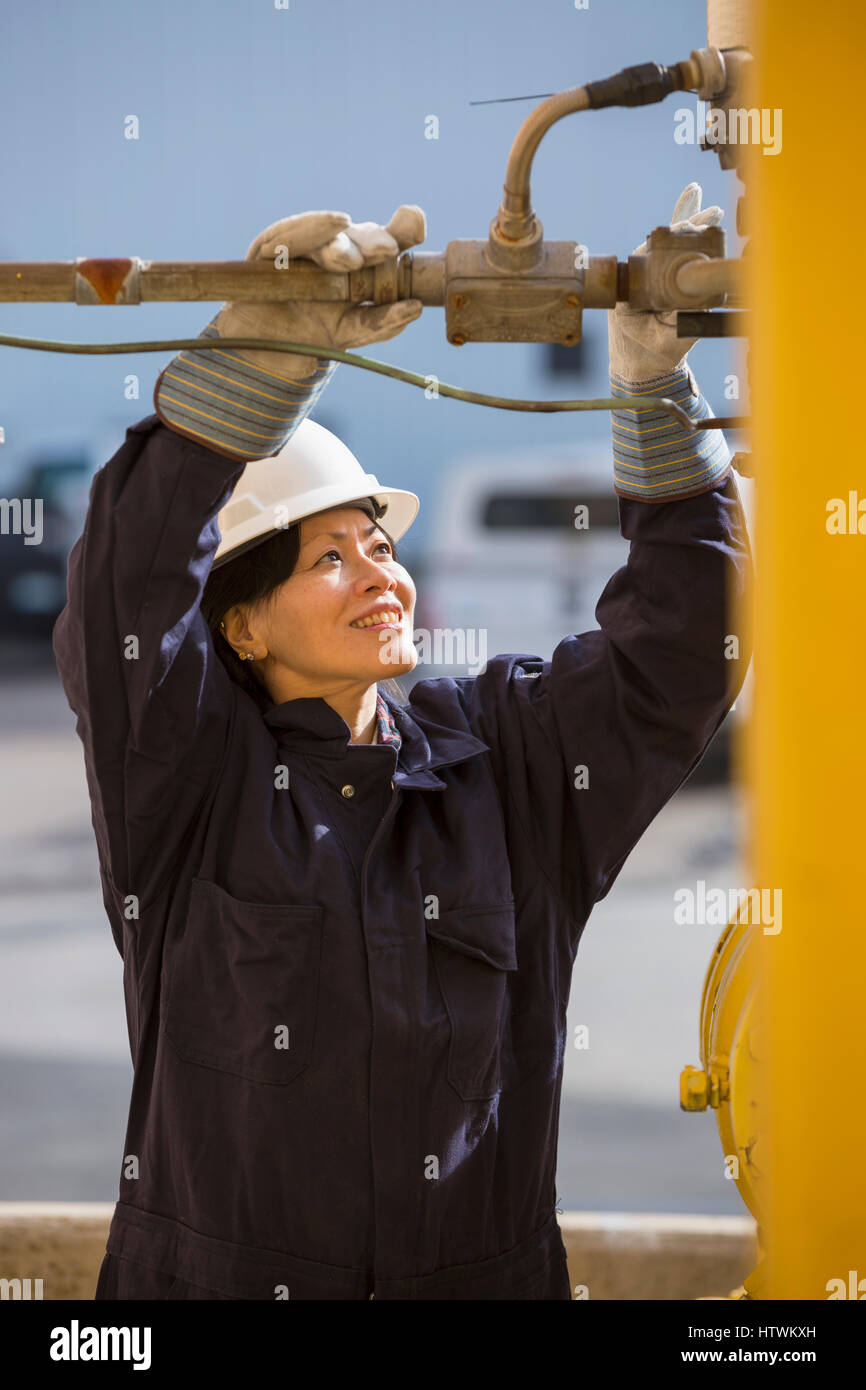 Female power engineer checking fuel line sensors at power plant Stock Photo