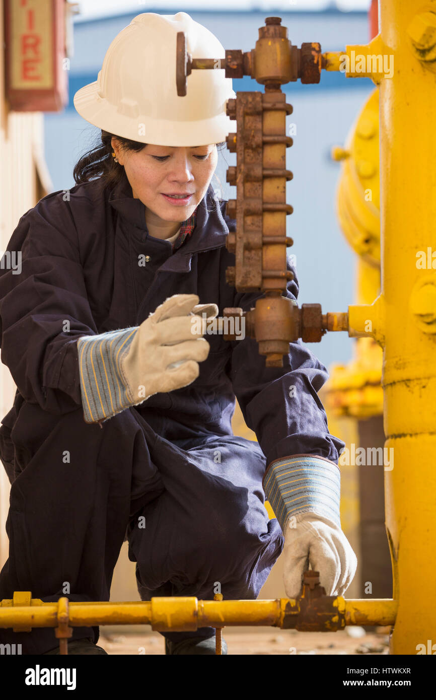 Female power engineer checking fuel line sensors at power plant Stock Photo