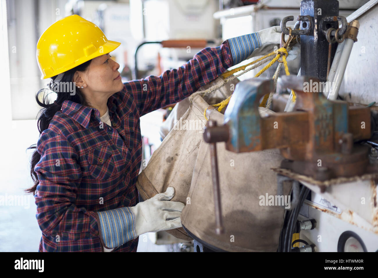Female power engineer securing equipment on bucket truck Stock Photo