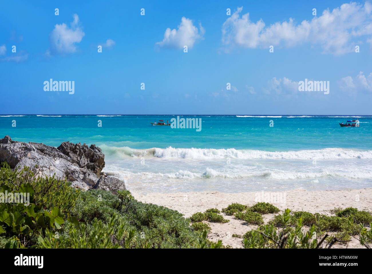 the Caribbean Sea and white sand beach in Tulum, Yucatan Peninsula, Mexico, with green grasses in the foreground Stock Photo