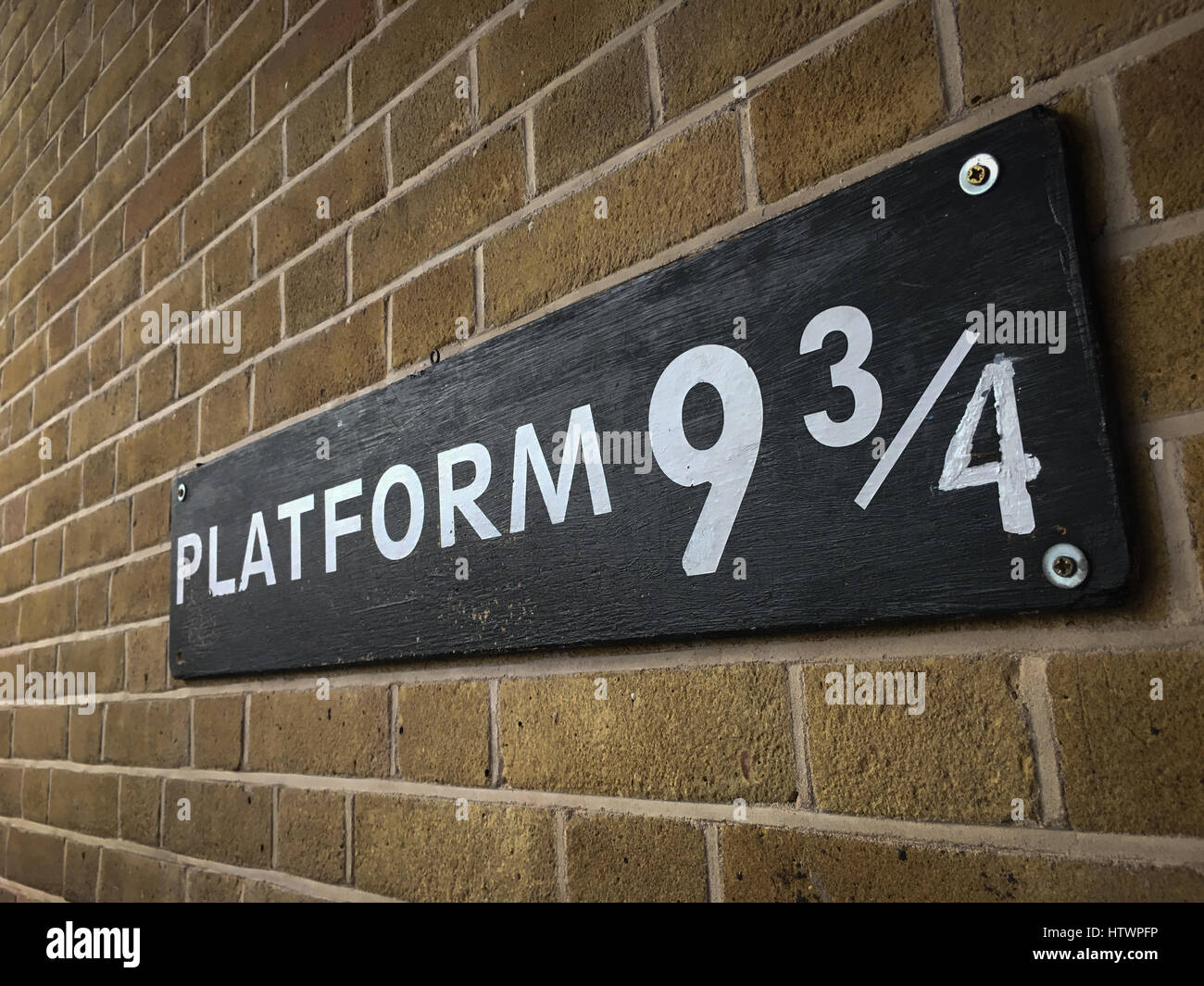 Platform ( & 3/4, for the train to Hogwarts School for Wizards, from Harry Potter stories, at King's Cross Station, London, England. Stock Photo