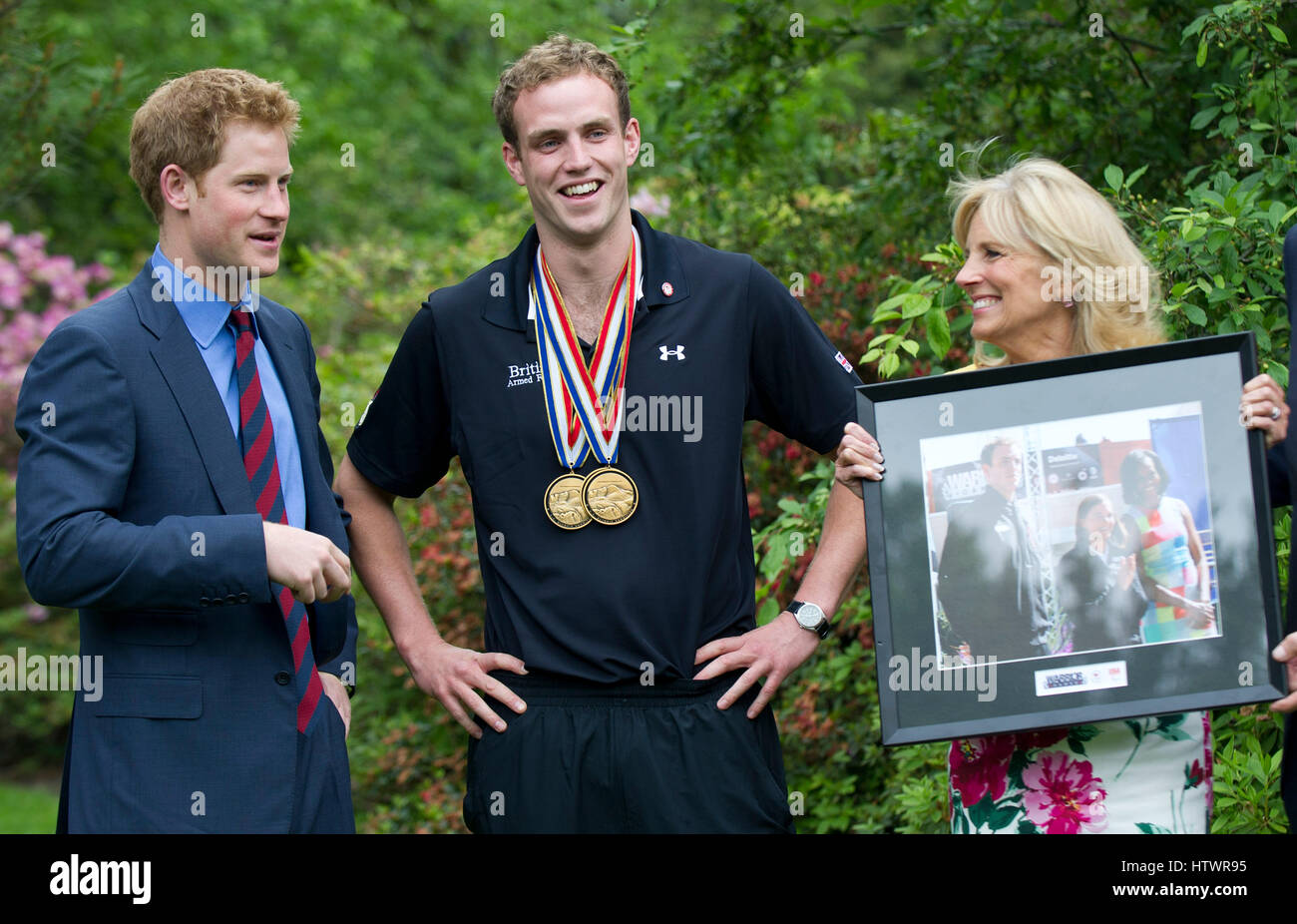 Prince Harry and Dr Jill Biden, the wife of U.S Vice President Joe Biden, talk with Captain Simon Maxwell, British Royal Marines, Wounded Warriors Games medalist during a reception for U.S and British wounded warriors at the British Ambassador's Residence Stock Photo