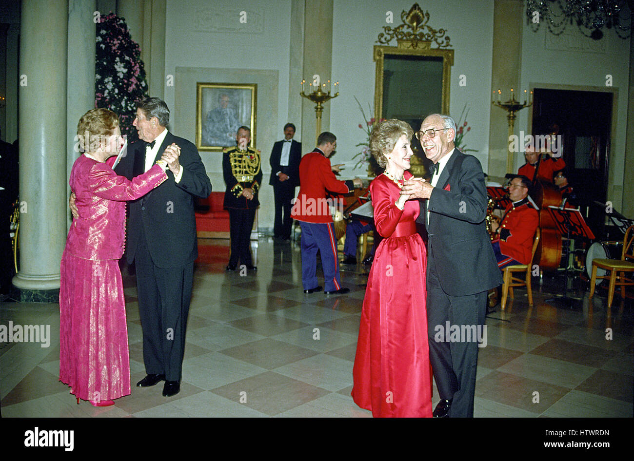 Washington, DC - (FILE) -- United States President Ronald Reagan and Prime Minister Margaret Thatcher of Great Britain share a dance in the Entrance Hall of the the White House in Washington, D.C following the dinner in her honor on Wednesday, November 16, 1988 At right their spouses, first lady Nancy Reagan and Denis Thatcher share a dance as well Stock Photo