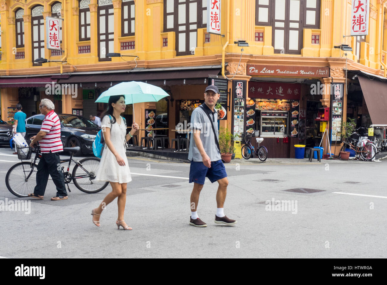 Pedestrian and cycling traffic on a street in suburban Singapore. Stock Photo