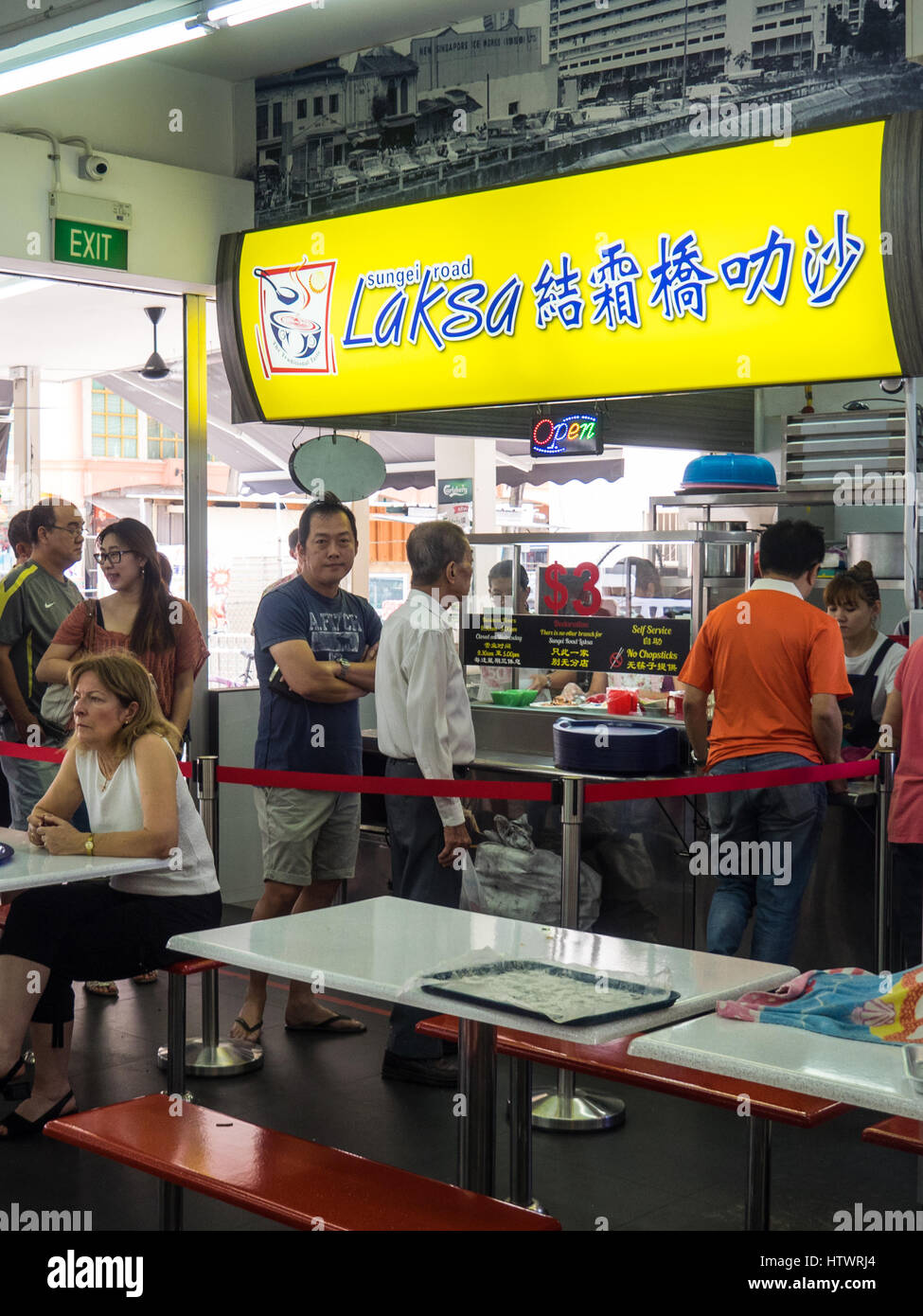 People queuing at a popular food stall for a bowl of curry laksa. Stock Photo