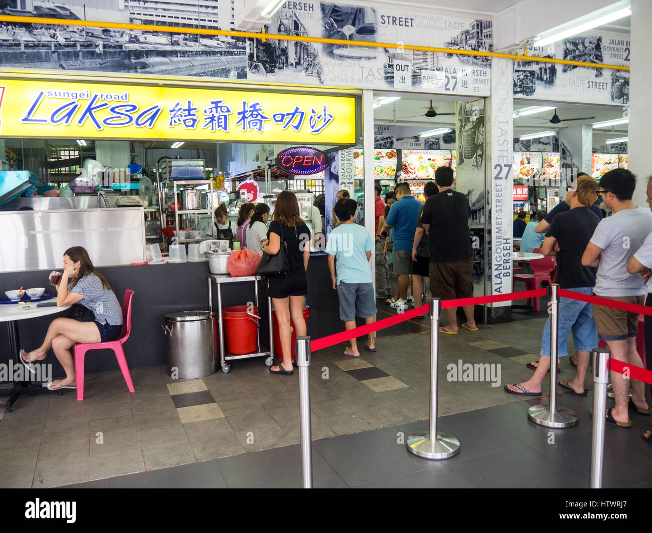 People queuing at a popular food stall for a bowl of curry laksa. Stock Photo