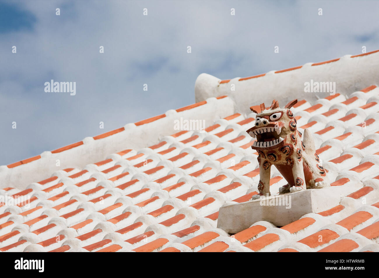 Shisa guardian dog on the roof top of a traditional Okinawan home. They are found on almost all roof tops or entrances of the homes on the island. Stock Photo