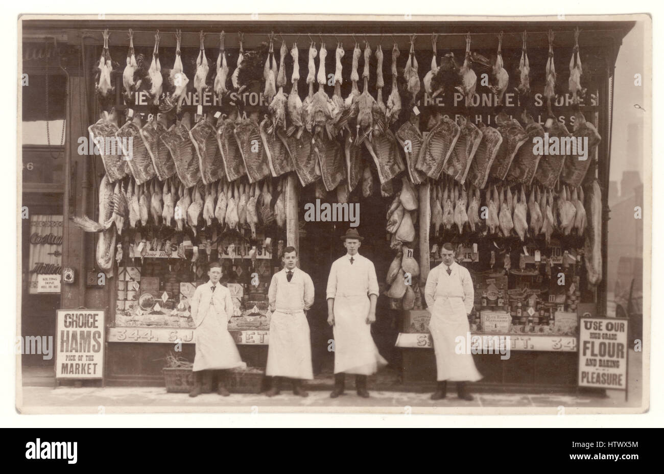 Edwardian era postcard photograph of Liggett's butcher's shop, meat displayed in window, group of men - staff or assistant, assistants, apprentices, standing outside, Bootle, Liverpool, England, U.K. circa 1913 Stock Photo