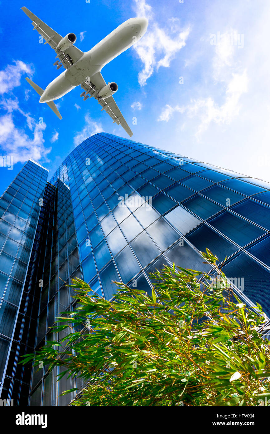 Skyscrapers with a flying airplane against blue sky Stock Photo - Alamy