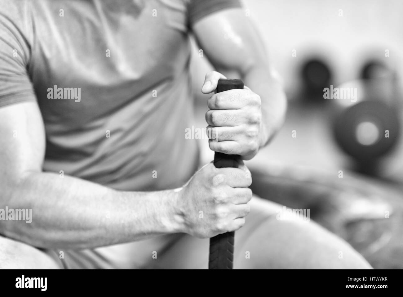 young muscular man after workout at gym with hammer and tractor tire