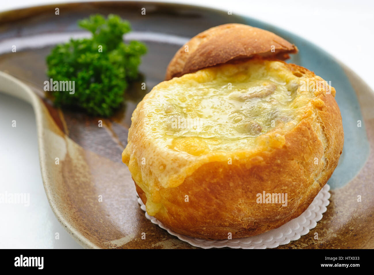 Cheese cream soup served in a loaf studio shot Stock Photo