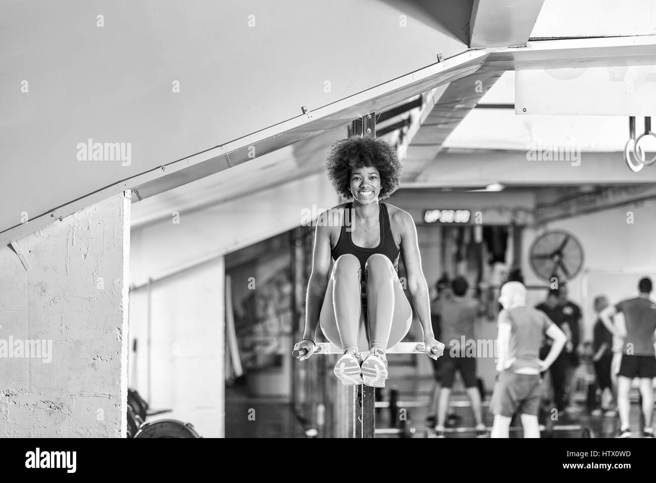 african american athlete woman workout out arms on dips horizontal parallel bars Exercise training triceps and biceps doing push ups Stock Photo
