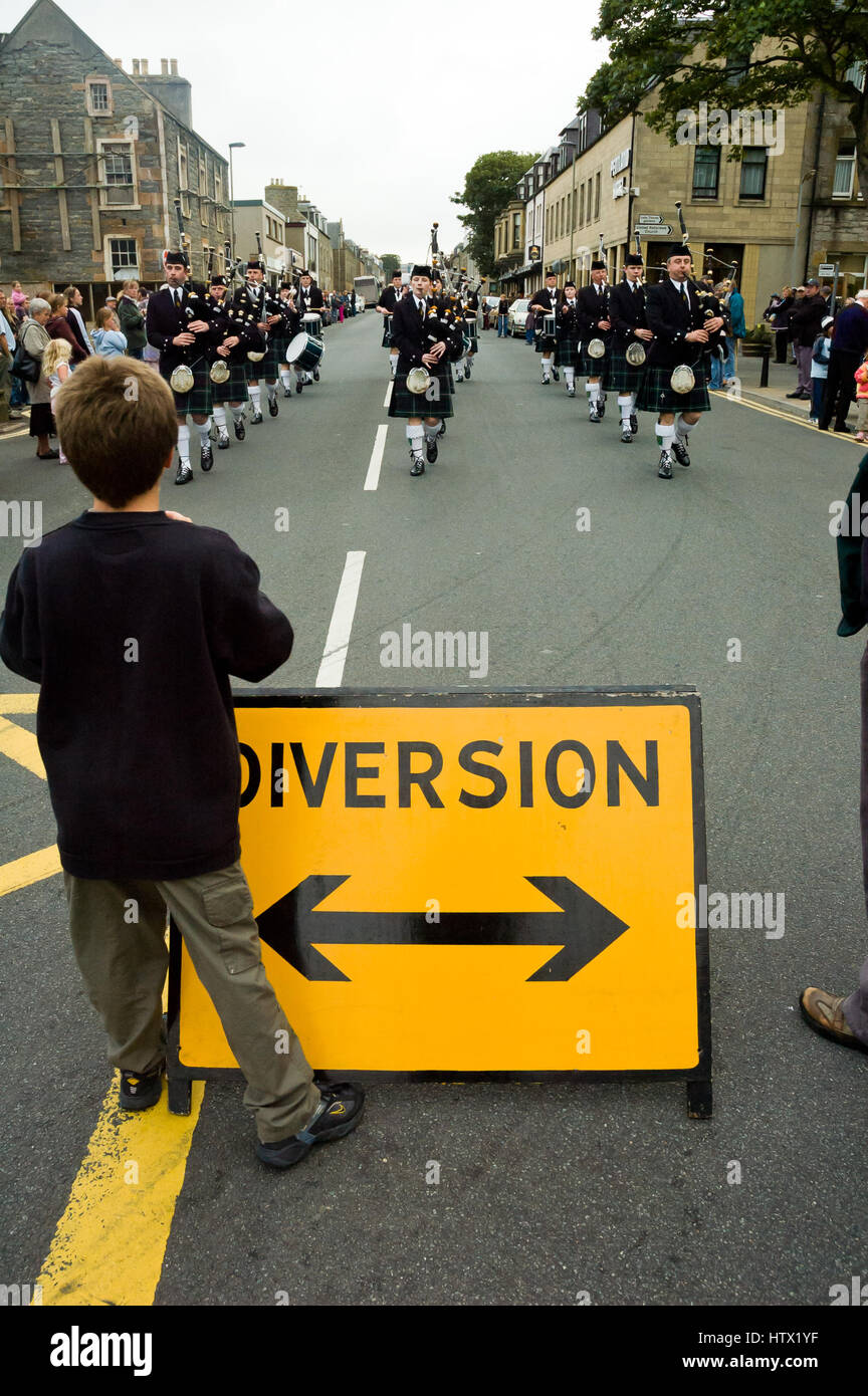 Scottish traditional bagpipes marching band on the street in Thurso