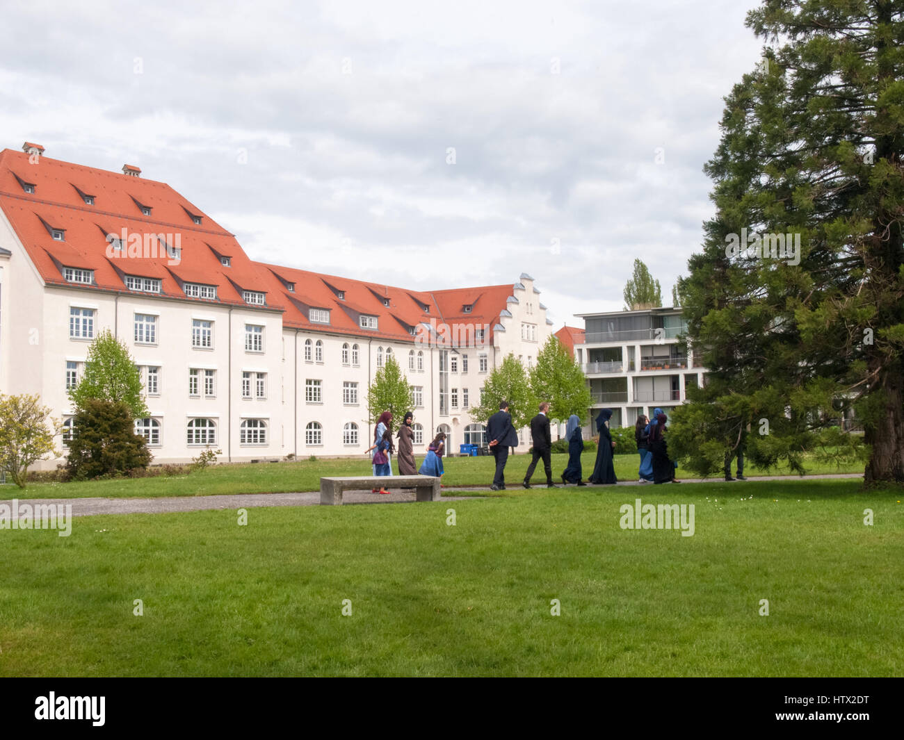 Lindau, Germany - May 2, 2015: Participants in a Turkish wedding as they walk in the park of Lindau. The photographer takes pictures to remember the e Stock Photo