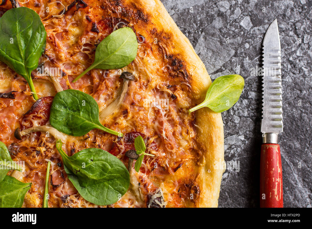 Homemade Pizza with Cheese, Ham, Salami, Baby Spinach and Shimeji Mushrooms. Fresh Baked Italian Food Ready to Eat. Stock Photo