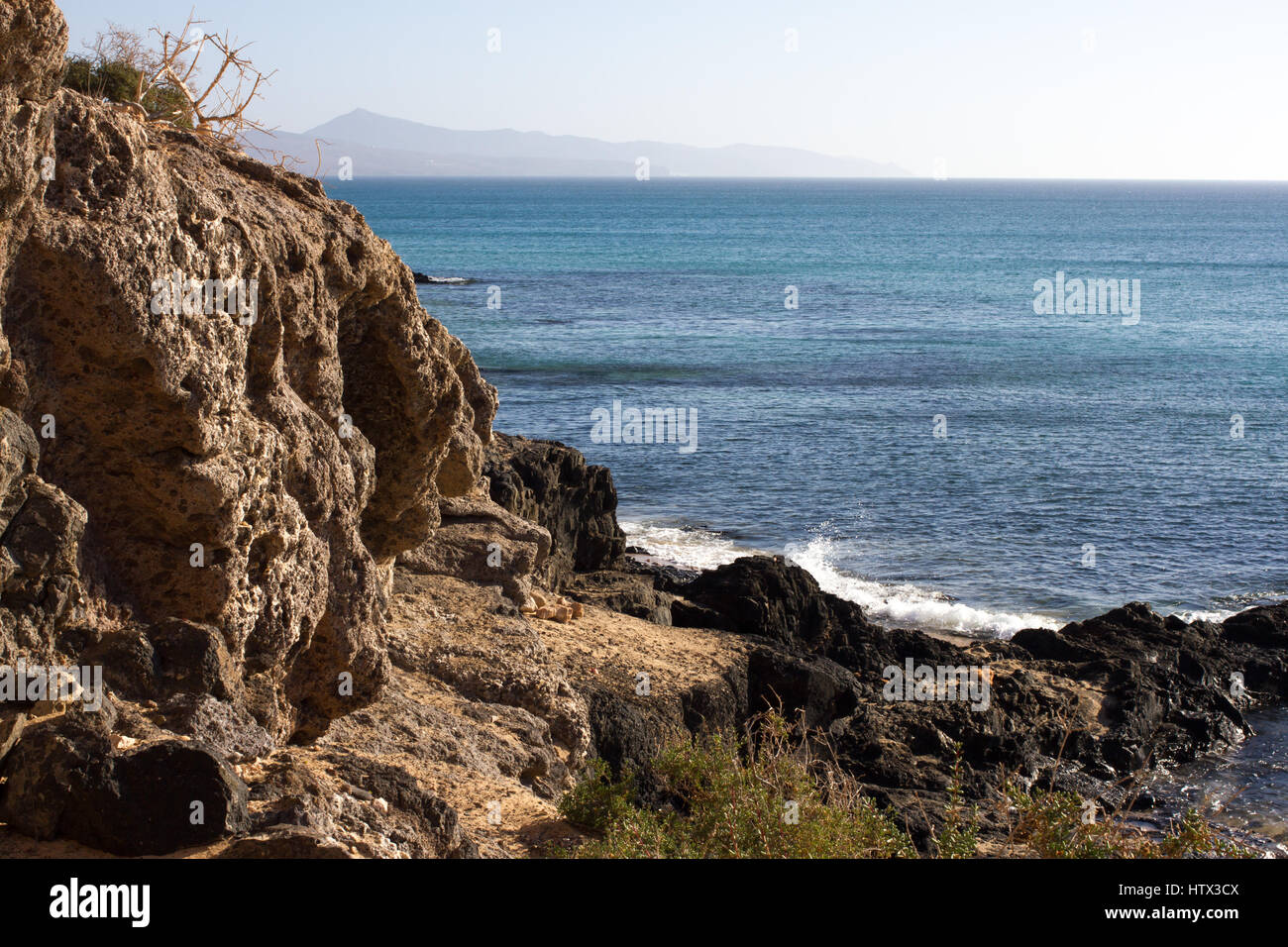 Black rocks of Costa Calma beach. Blue coastline. Playa Barca, Fuerteventura, Canary islands, Spain. Istmo de la pared view Stock Photo