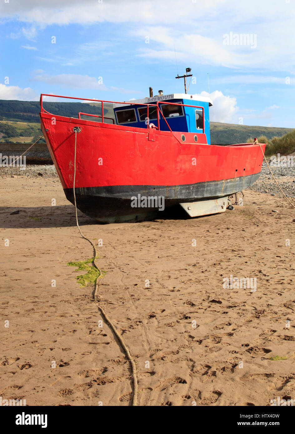 A boat sits on Barmouth Sands, Barmouth, Wales, Europe Stock Photo